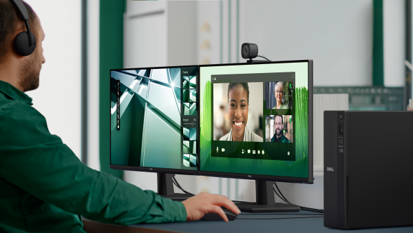 Pracownik biurowy uczestniczący w konferencji internetowej na żywo przy użyciu kompaktowego komputera stacjonarnego Dell Slim z wieloma monitorami firmy Dell