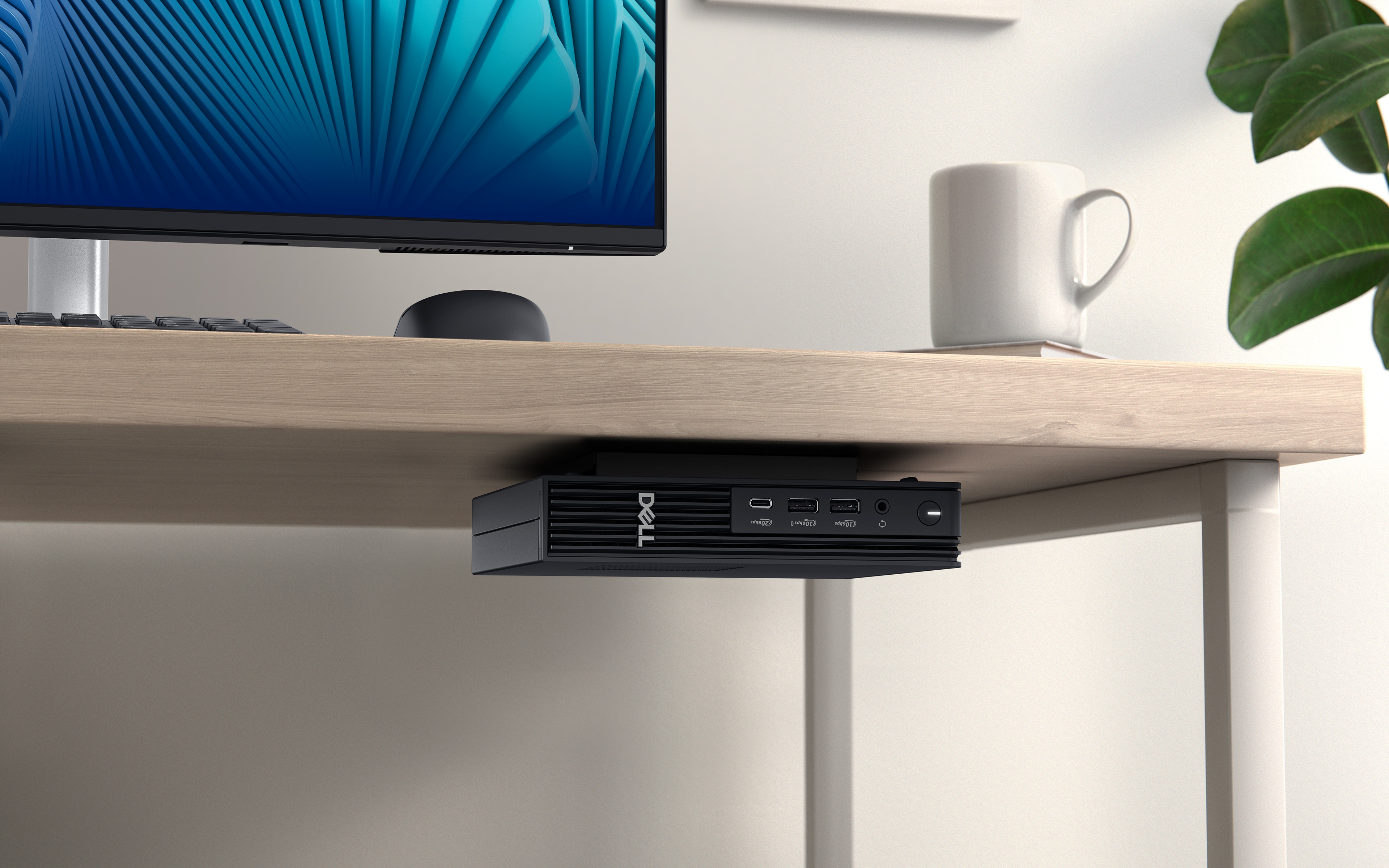 Komputer Dell Pro Micro Plus zamontowany pod biurkiem w domu.