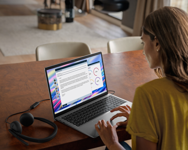 Osoba pracująca na komputerze Dell 15 z podłączonymi słuchawkami.
