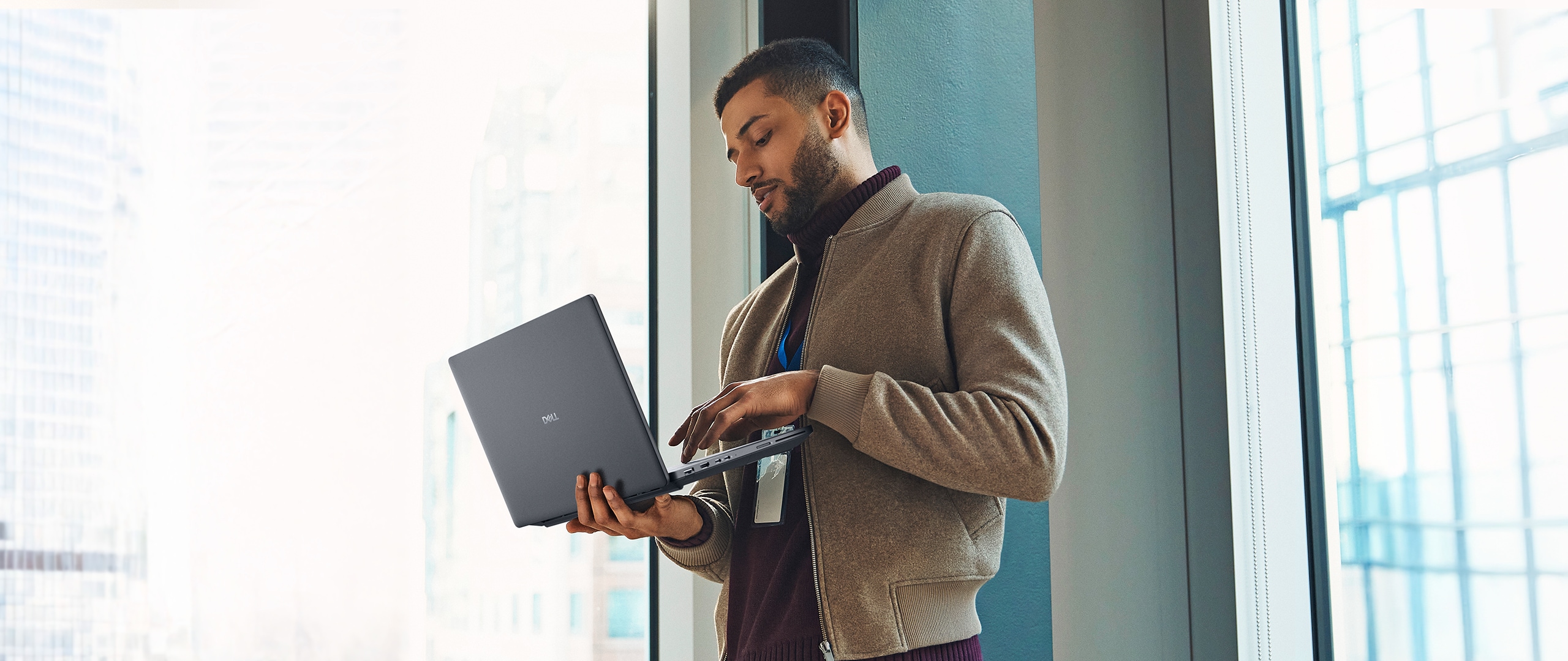 Stojący mężczyzna podczas pracy na notebooku Dell Pro Max.